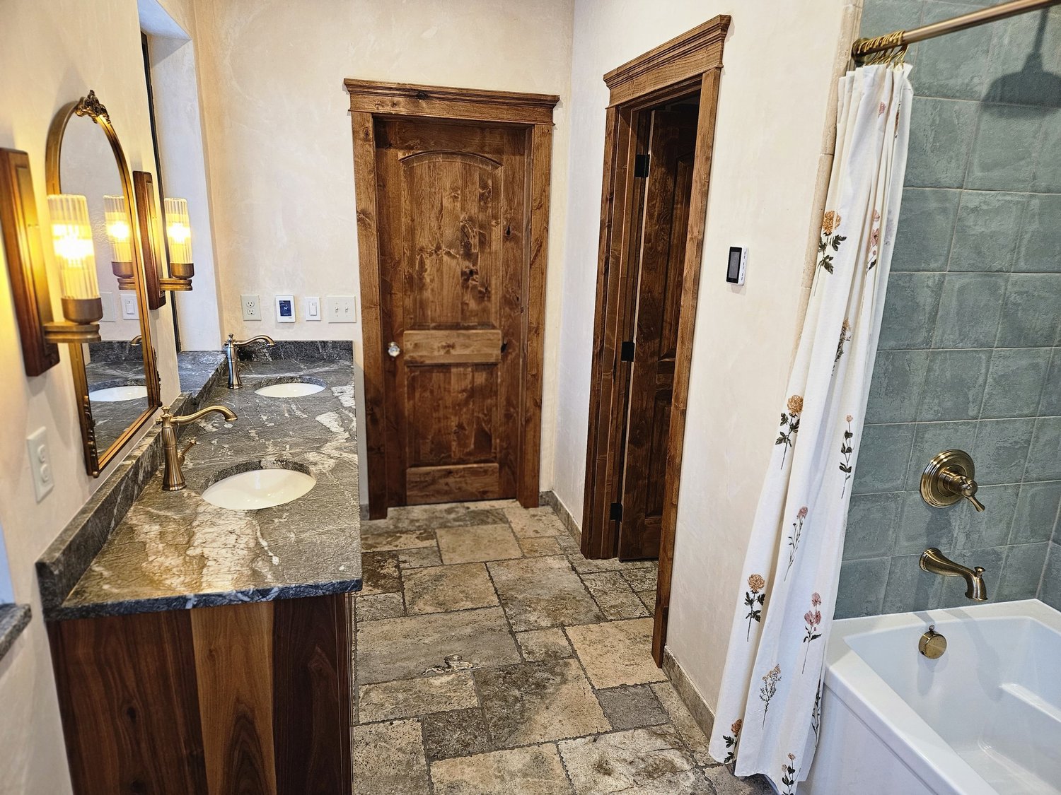 Stone-tiled bathroom remodel with brass fixtures